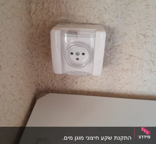 שקע חשמלי עם כיסוי שקוף על קיר